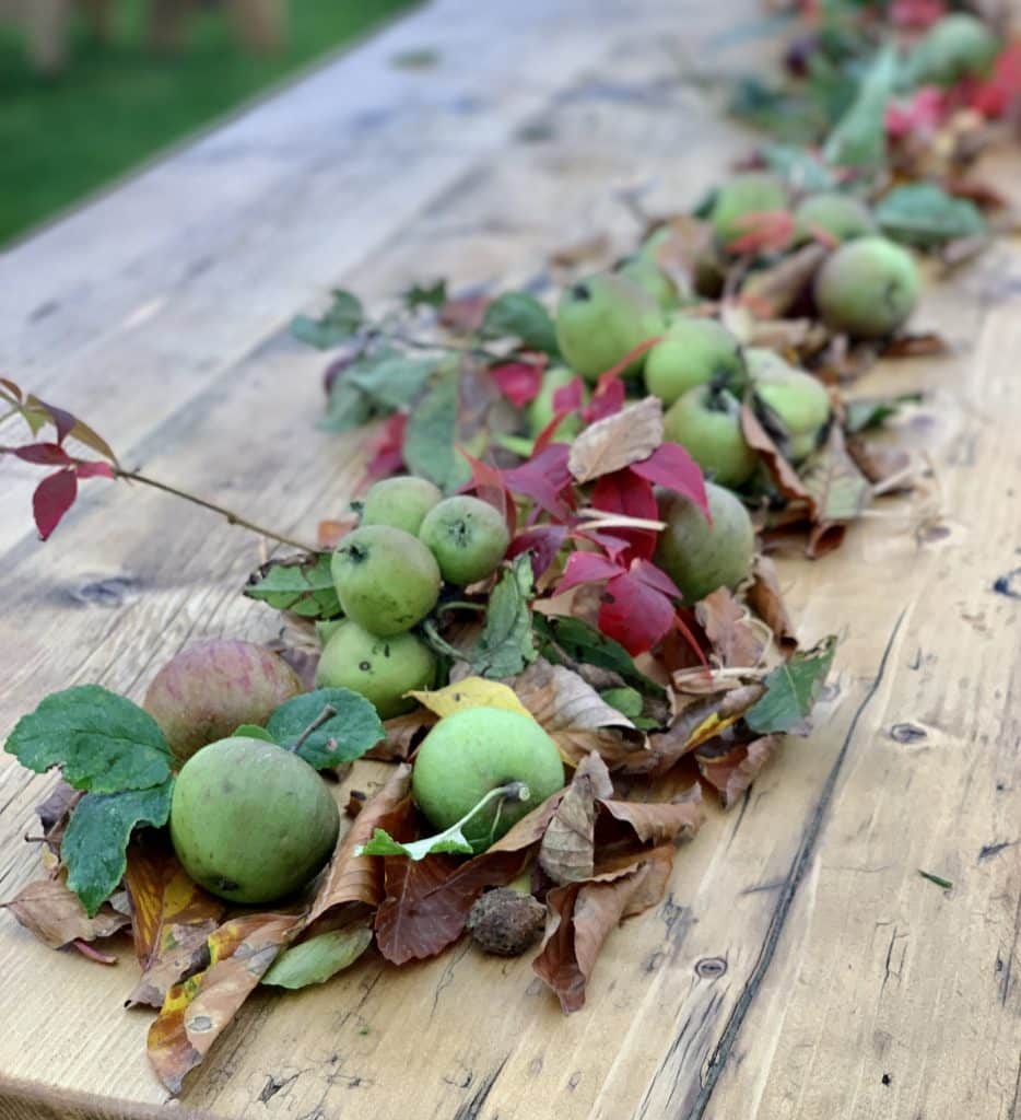 Wooden trestle table for hire decorated in autumnal leaves
